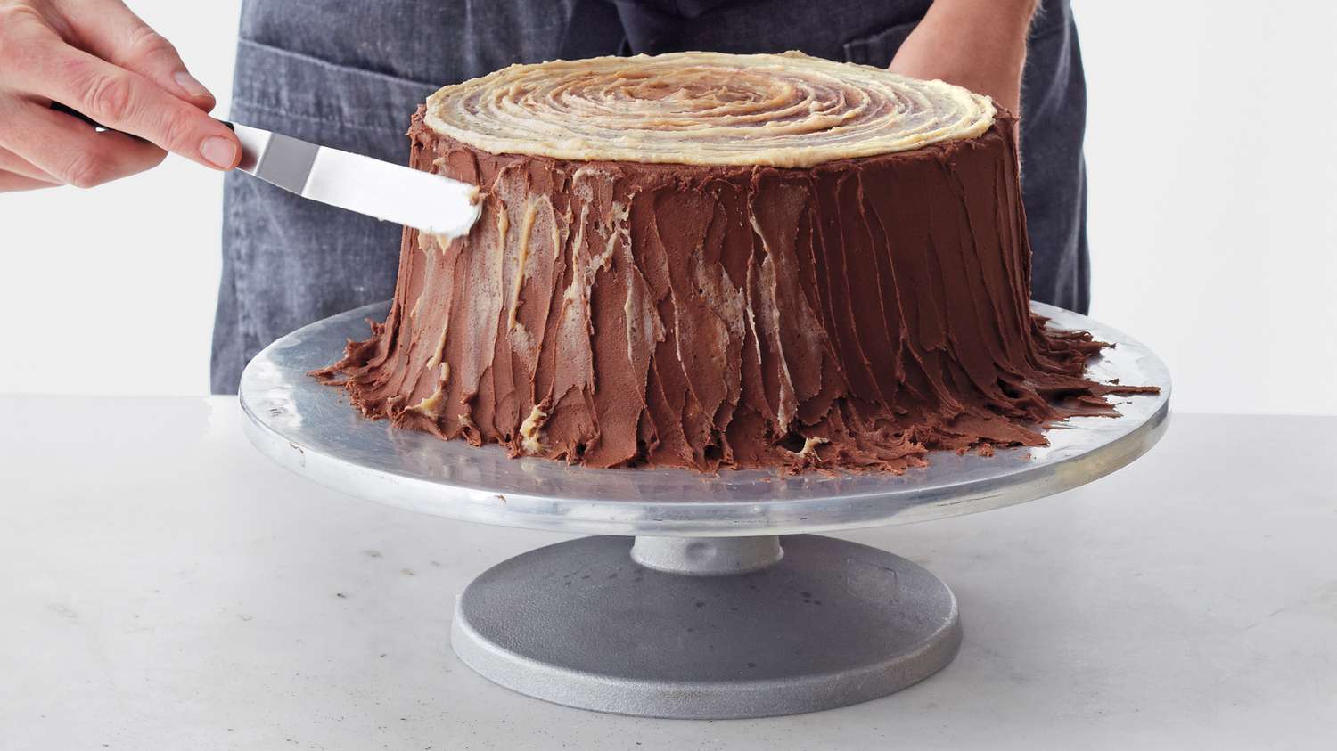 yule log layer cake adding chestnut frosting to sides as highlight