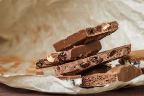 Stack of chocolate bark with nuts and raisins on parchment paper