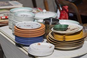 Stacks of various plates and kitchenware on a table