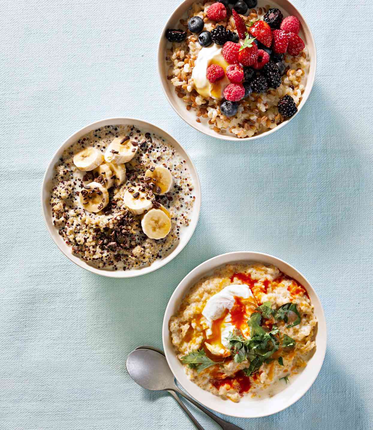 three different types of breakfast bowls on pale blue linen tablecloth