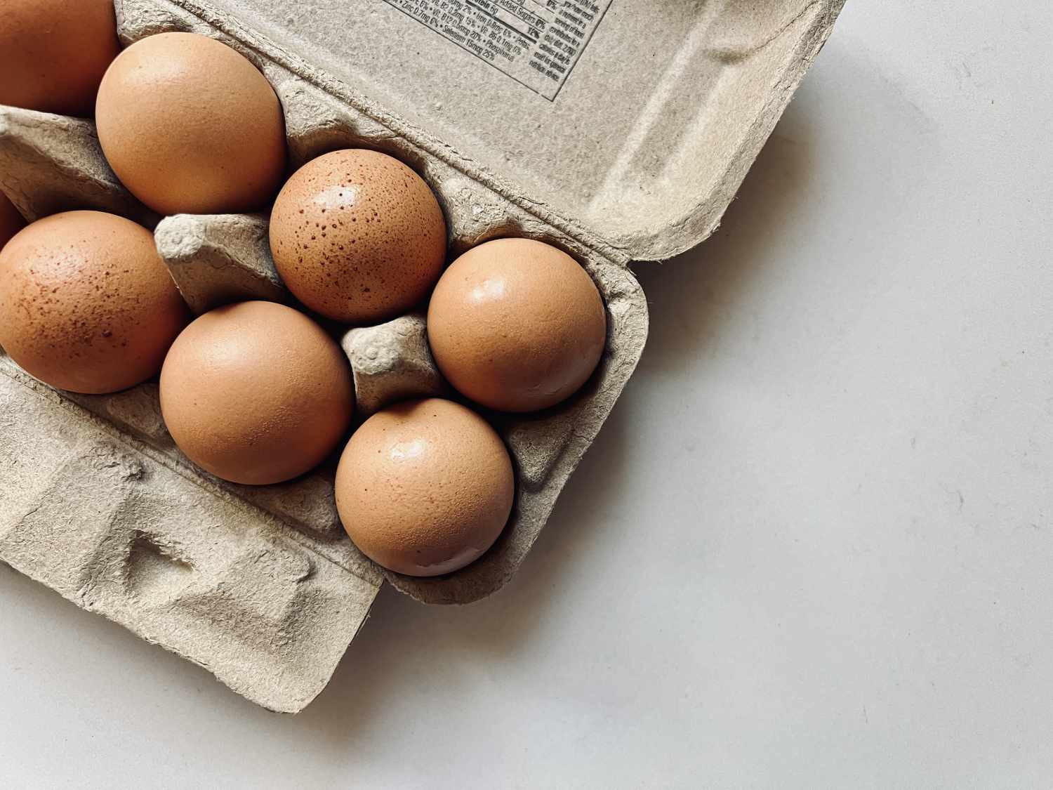Eggs resting on a white kitchen counter. 