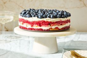 Layered dessert with blueberries on top presented on a cake stand