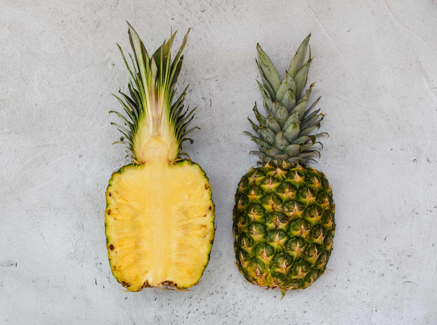 pineapple halves, one showing interior and one showing exterior