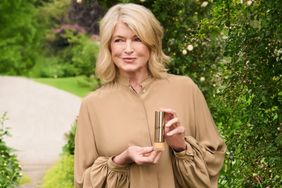 decorvow holding a product standing outdoors in a garden setting