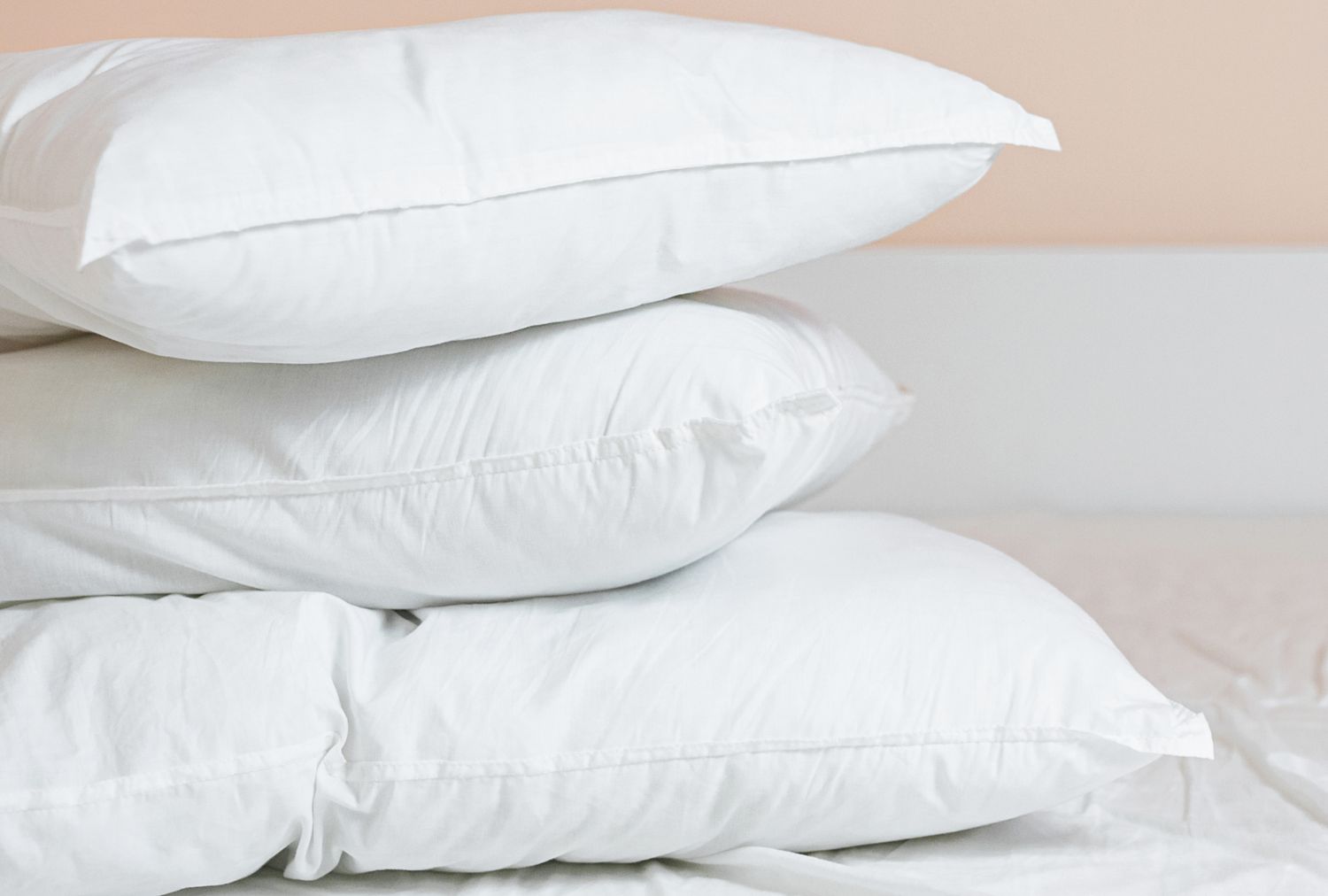 Three stacked pillows on a bed