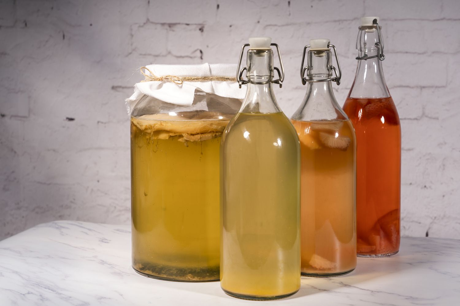 a jar and several bottles of homemade kombucha