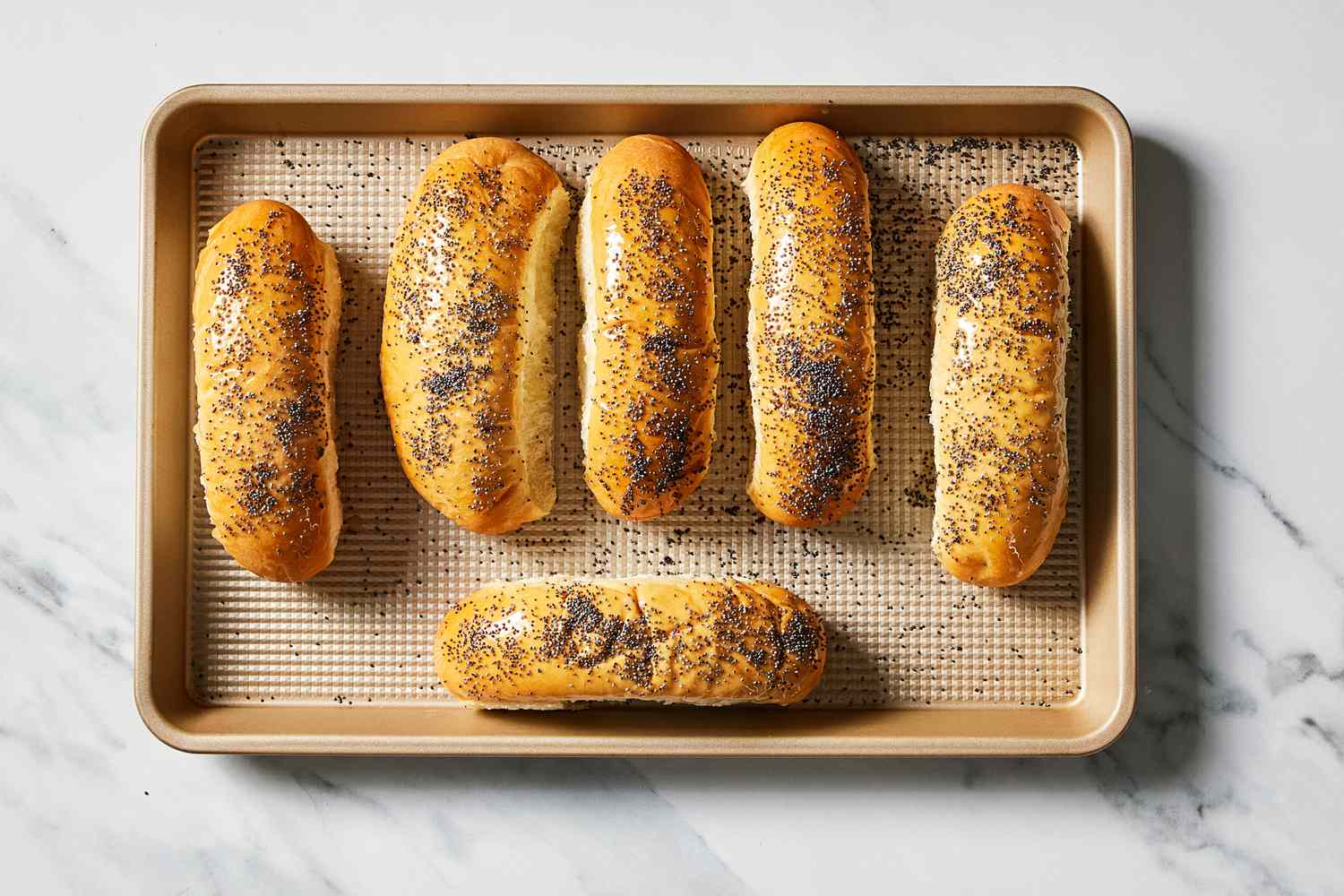 Hot dog buns on baking sheet