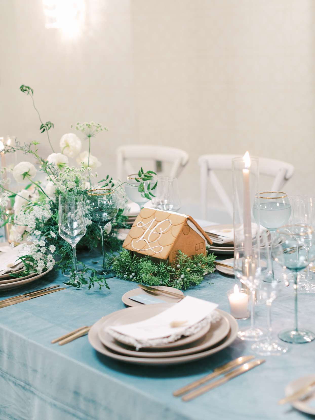 elegant blue table setting with decorative gingerbread houses and candles