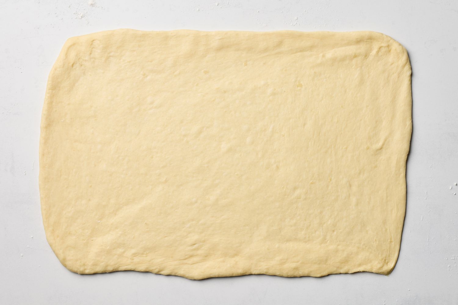 A rolled out sheet of dough on a flat surface ready for preparation