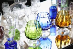 A selection of colored glassware on a reflective surface