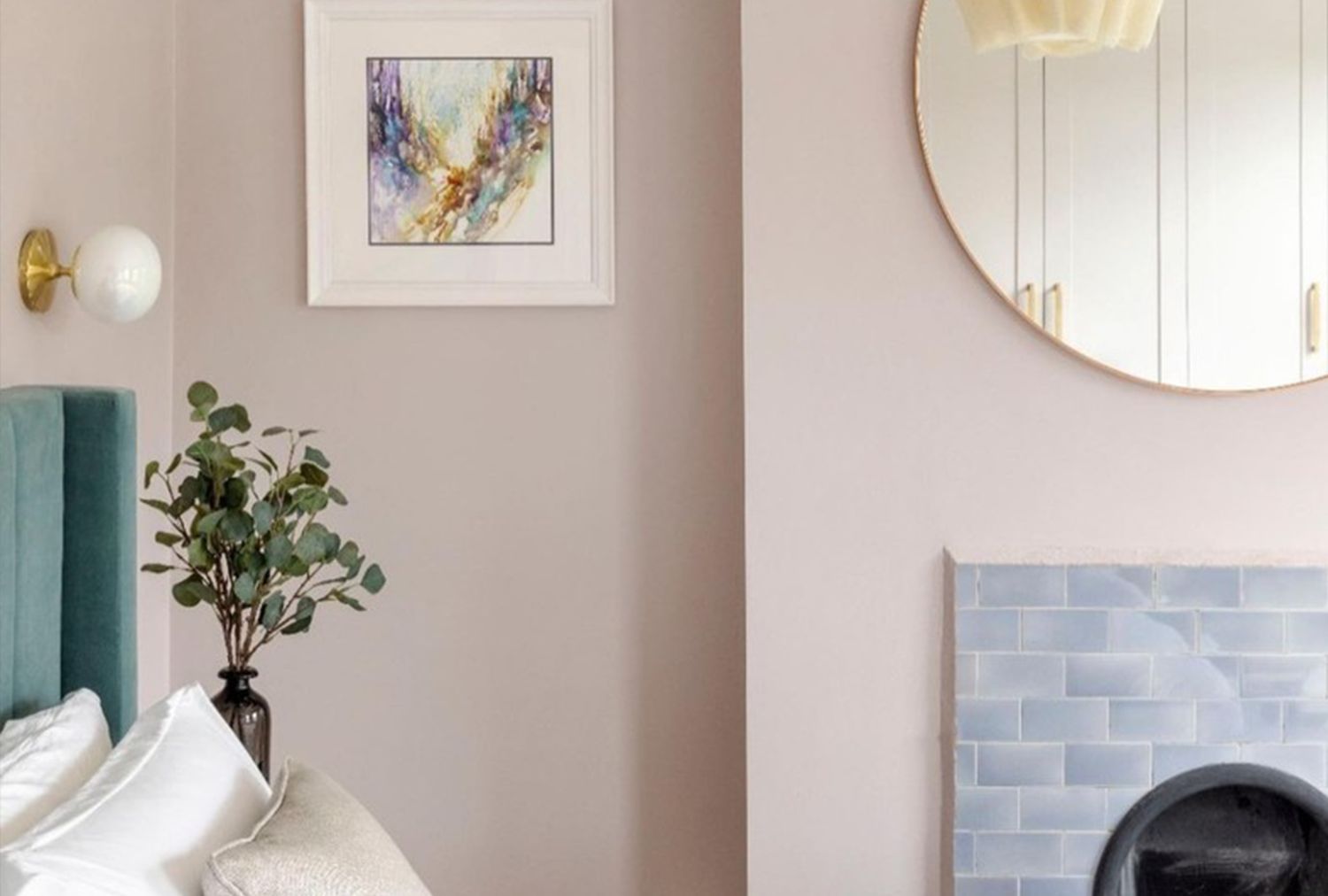 Modern interior with a bed circular mirror abstract artwork and fireplace tiled in light textures