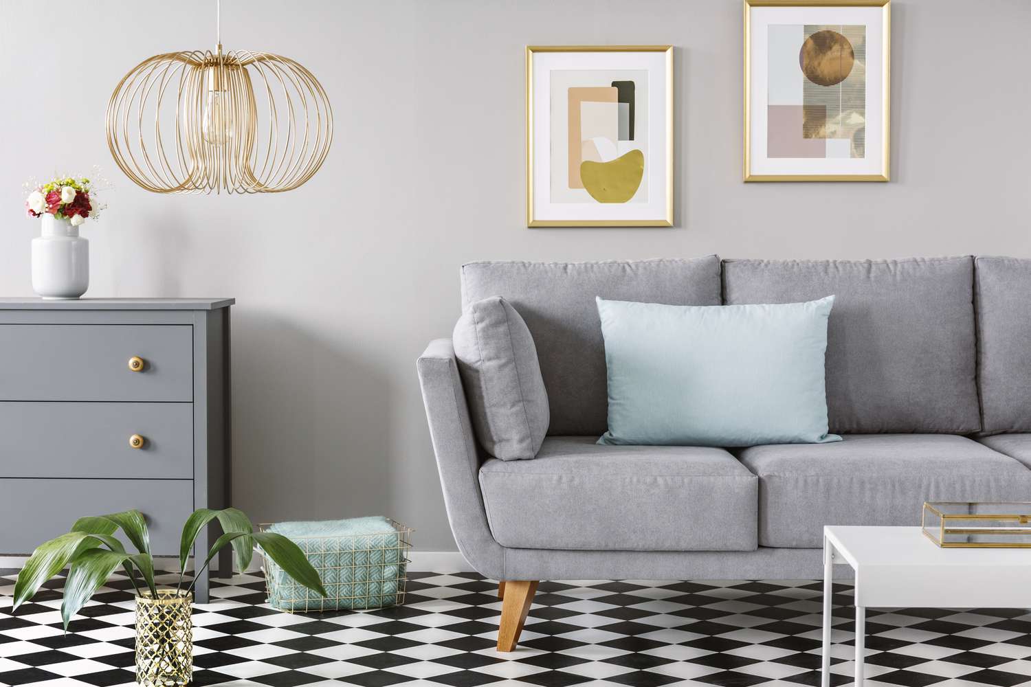 grey couch in bright living room interior with checkerboard linoleum floo