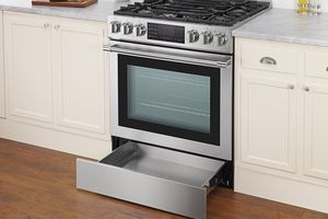 A kitchen oven with a bottom drawer open