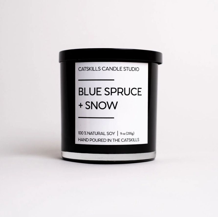 A Catskills Candle Studio candle labeled Blue Spruce Snow