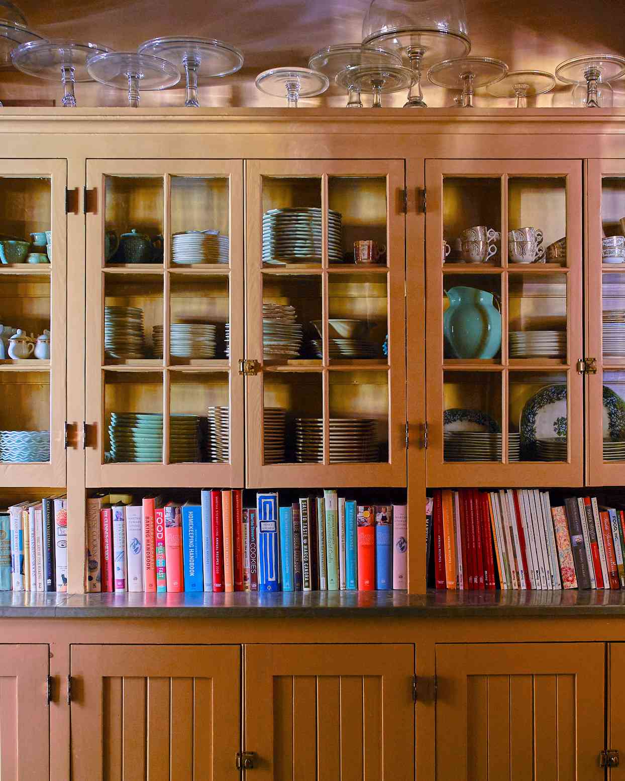 dishes and cookbooks line cupboards