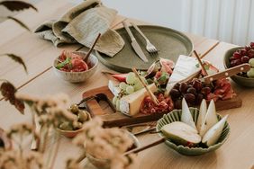 Assorted food items including cheese, fruit, and meat on a table setting