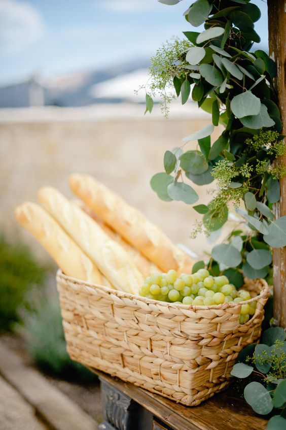 grapes and baguettes in woven baskets