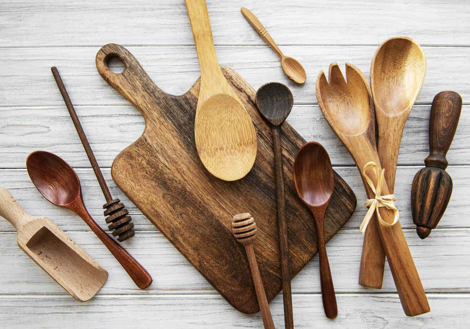Assorted wooden kitchen utensils on a rustic wooden surface