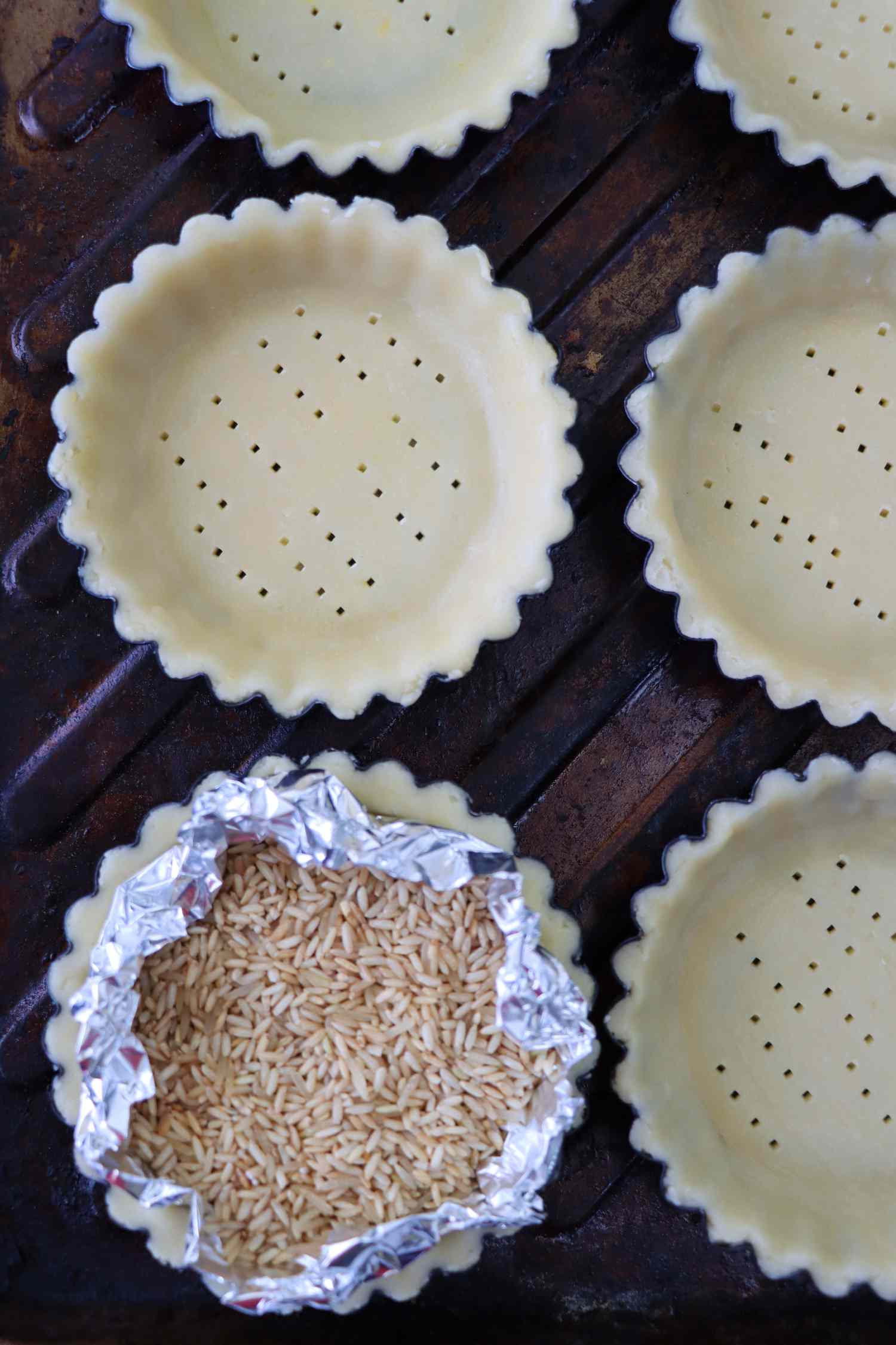 tart shells to be blind baked, one lined with foil and filled with rice