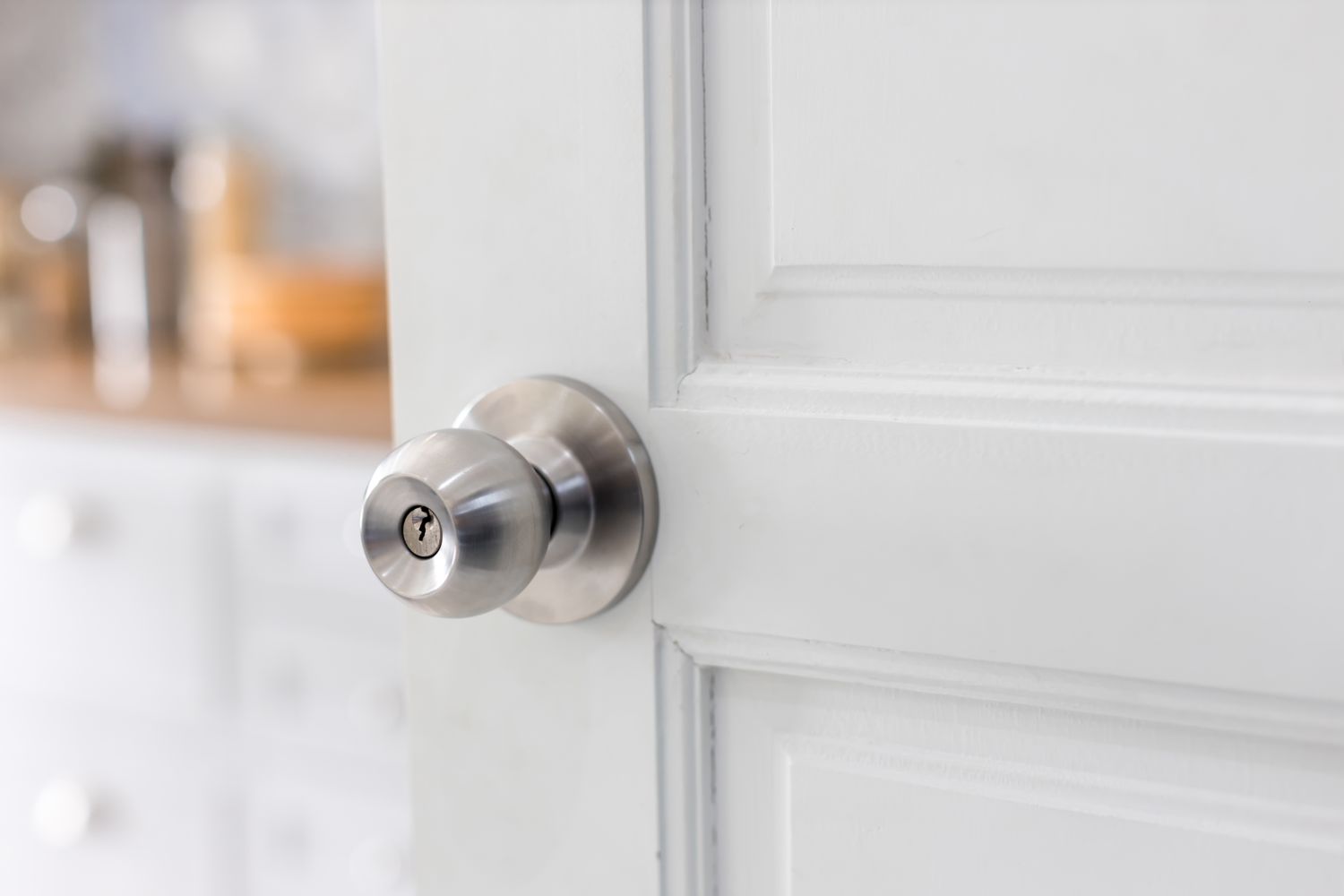 Door with grill, stainless door knob or handle on wooden door in beautiful lighting.a handle on a door that is turned to release the latch.