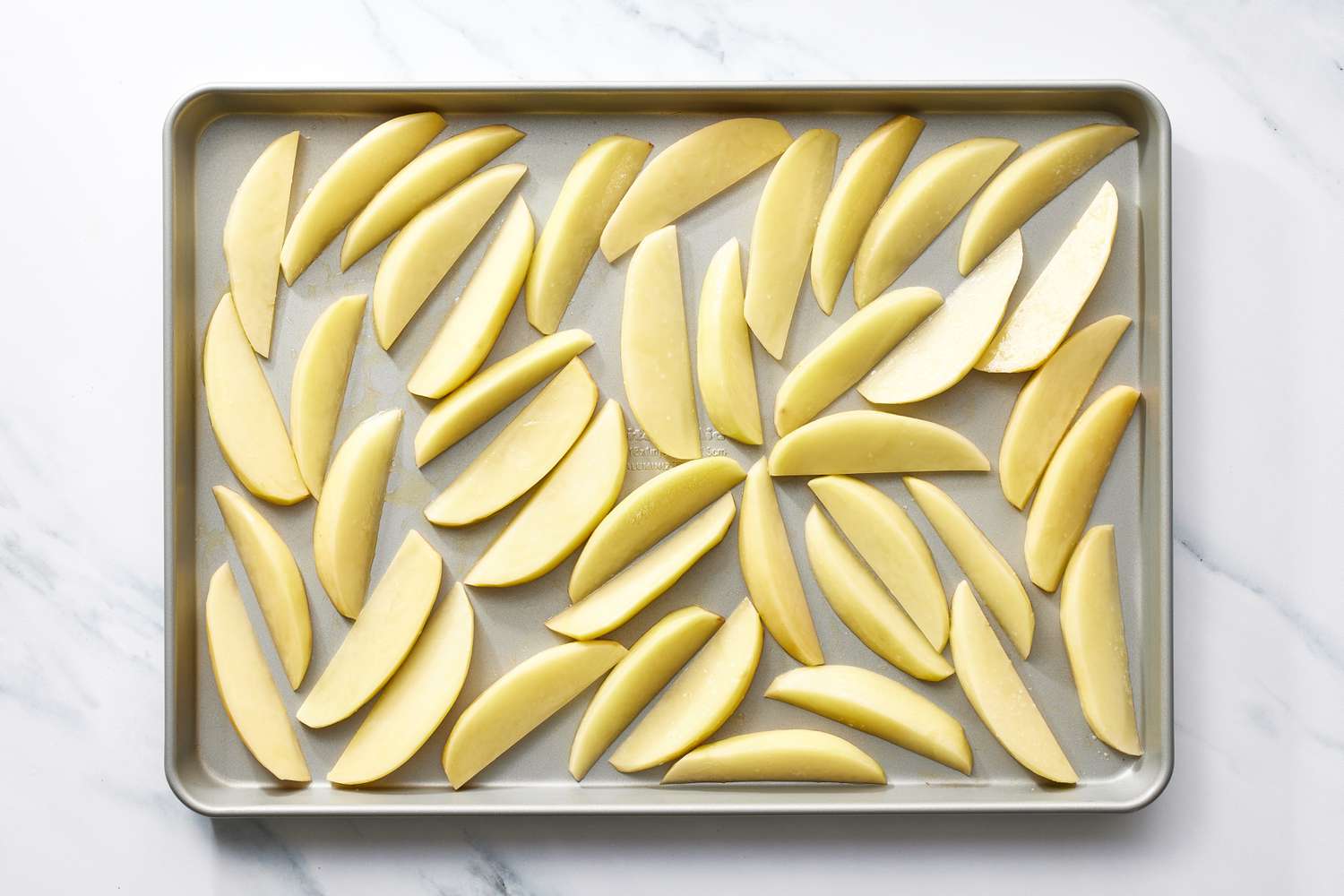 Potato wedges on baking sheet