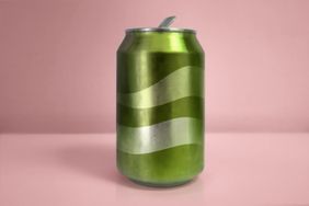 A soda can with a wavy stripe design displayed on a pink background
