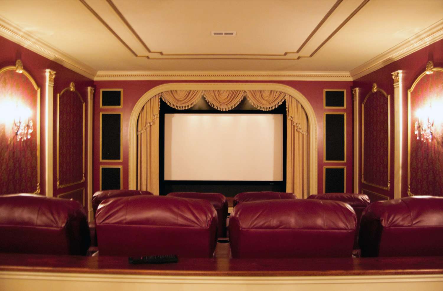 A luxurious home theater with a projector screen and leather seating