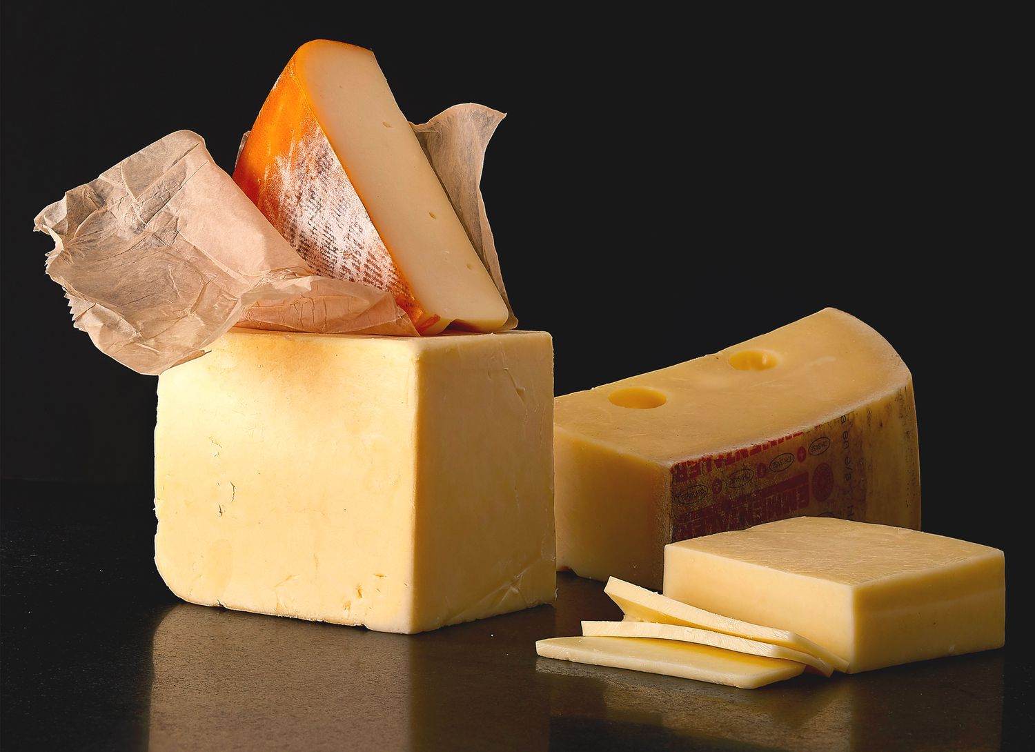 multiple cheeses on a dark background
