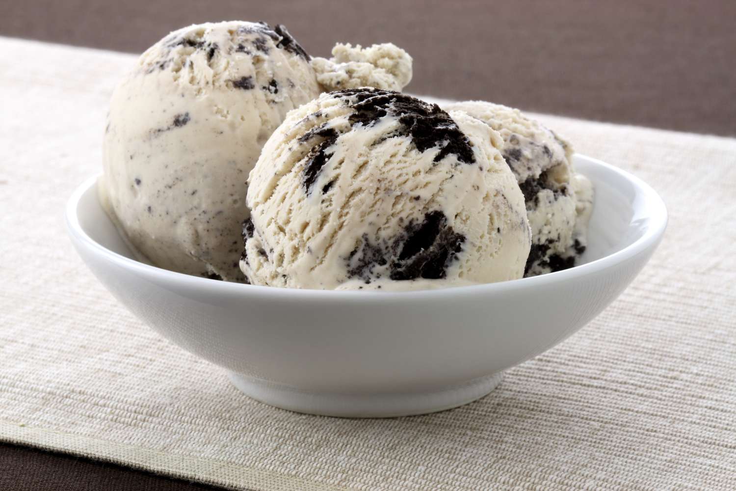 A bowl containing two scoops of cookies and cream ice cream