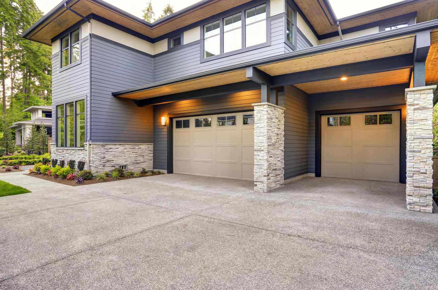 A modern house with a double garage and stone accents in a residential area