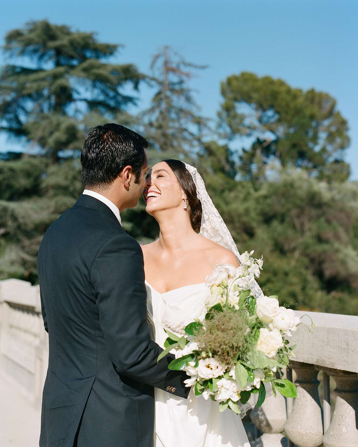 pia davide wedding couple against stone railing