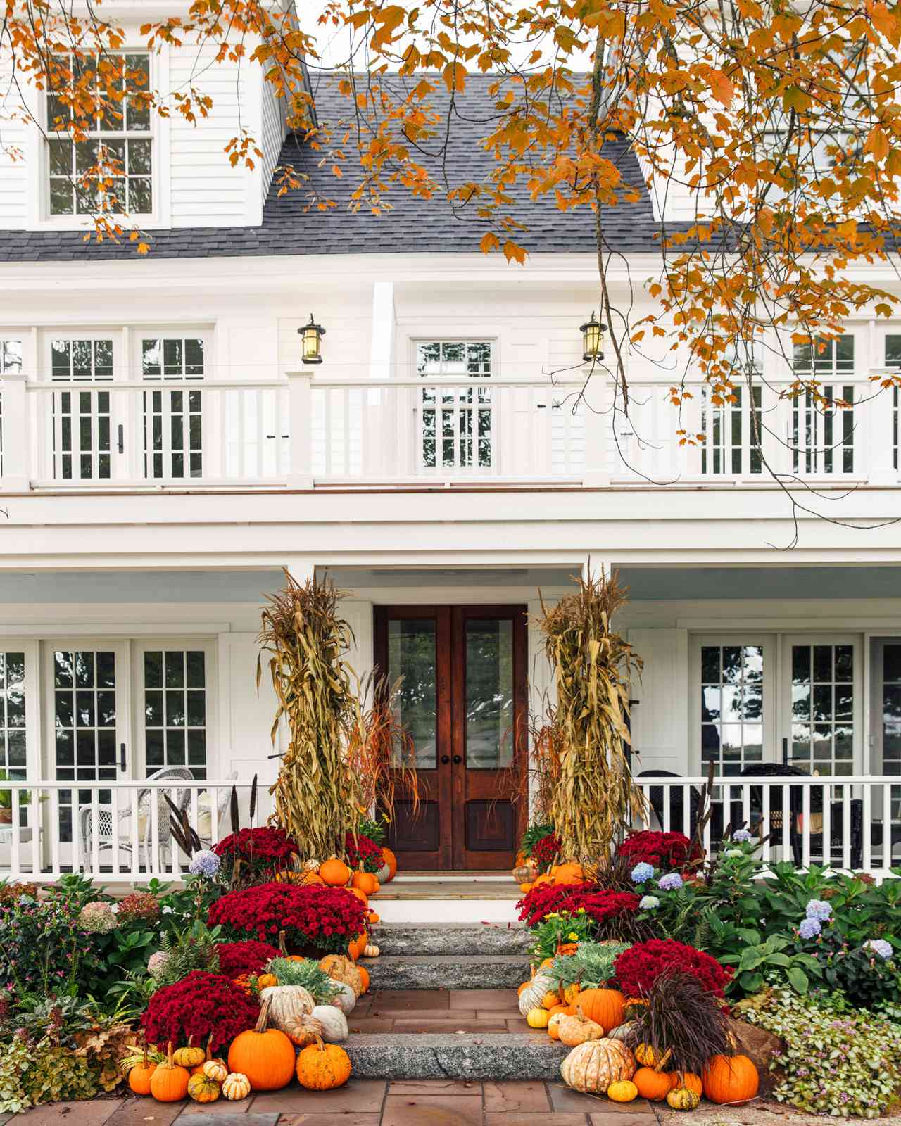 fall porch with colorful florals pumpkins and ghourds