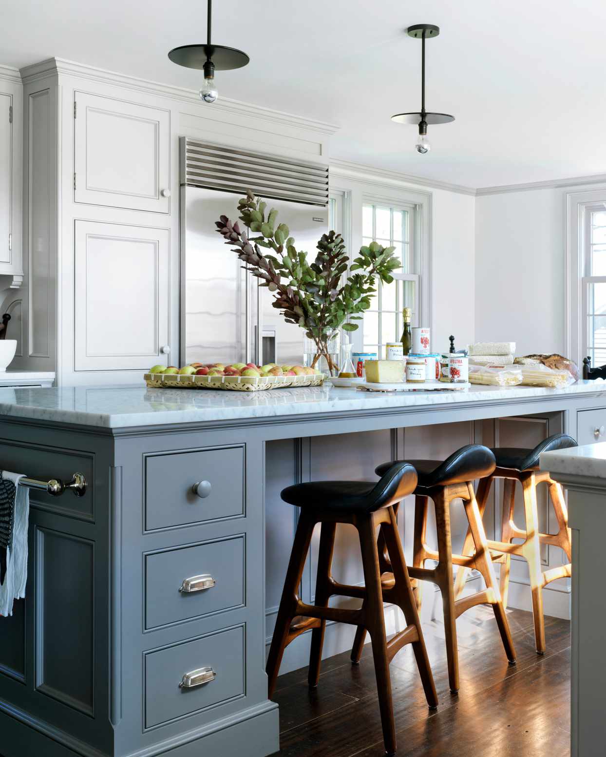 marble kitchen island with barstools and painted cabinetry