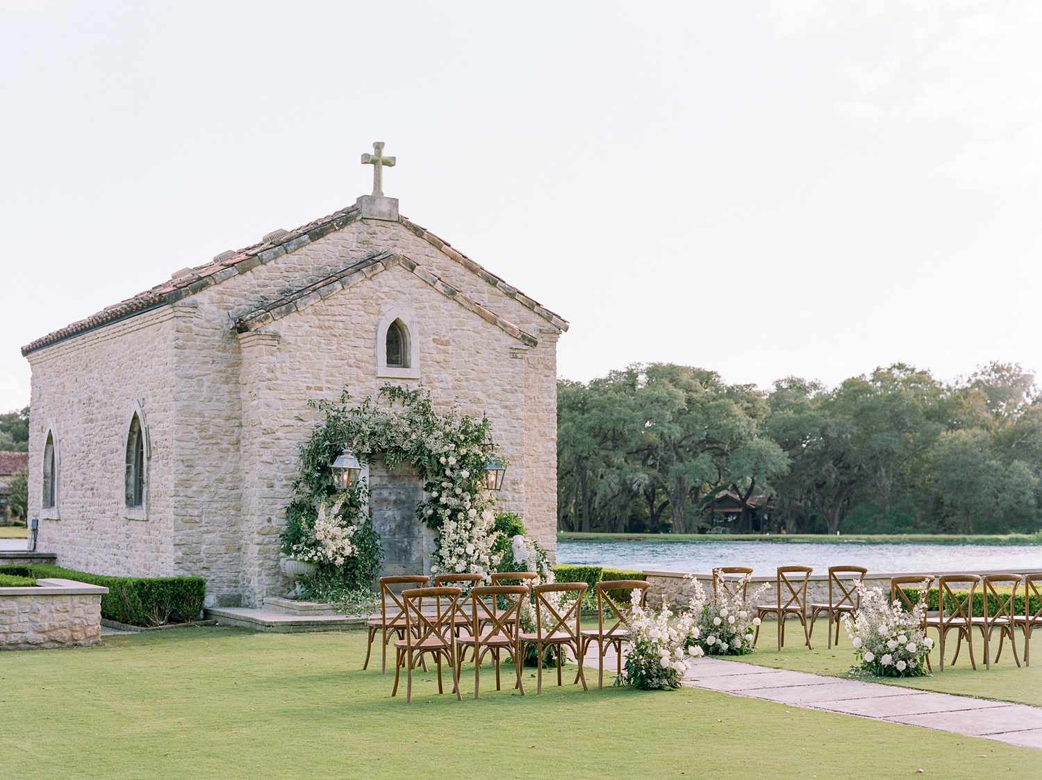 outdoor wedding setup with rows of chairs and a floral archway