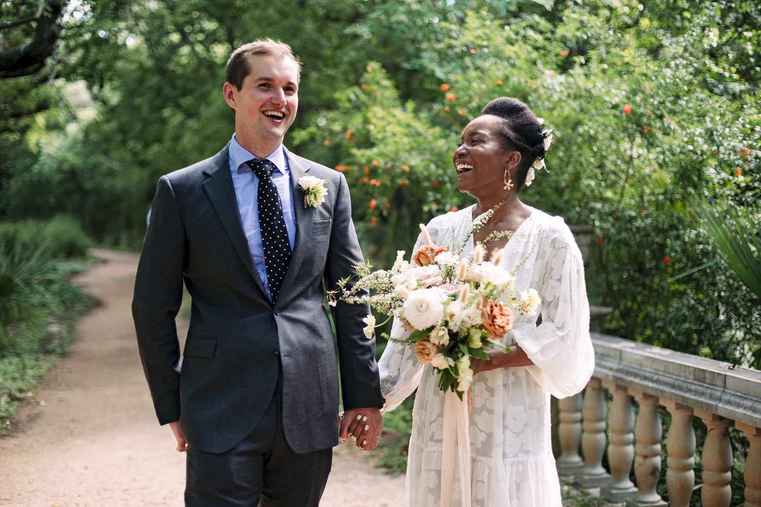 Bride and groom laughing on a bridge
