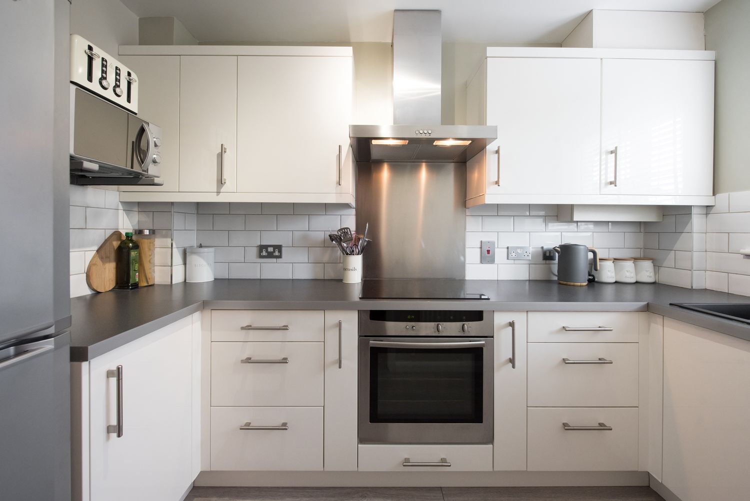 Modern kitchen with white cabinets and stainless steel appliances