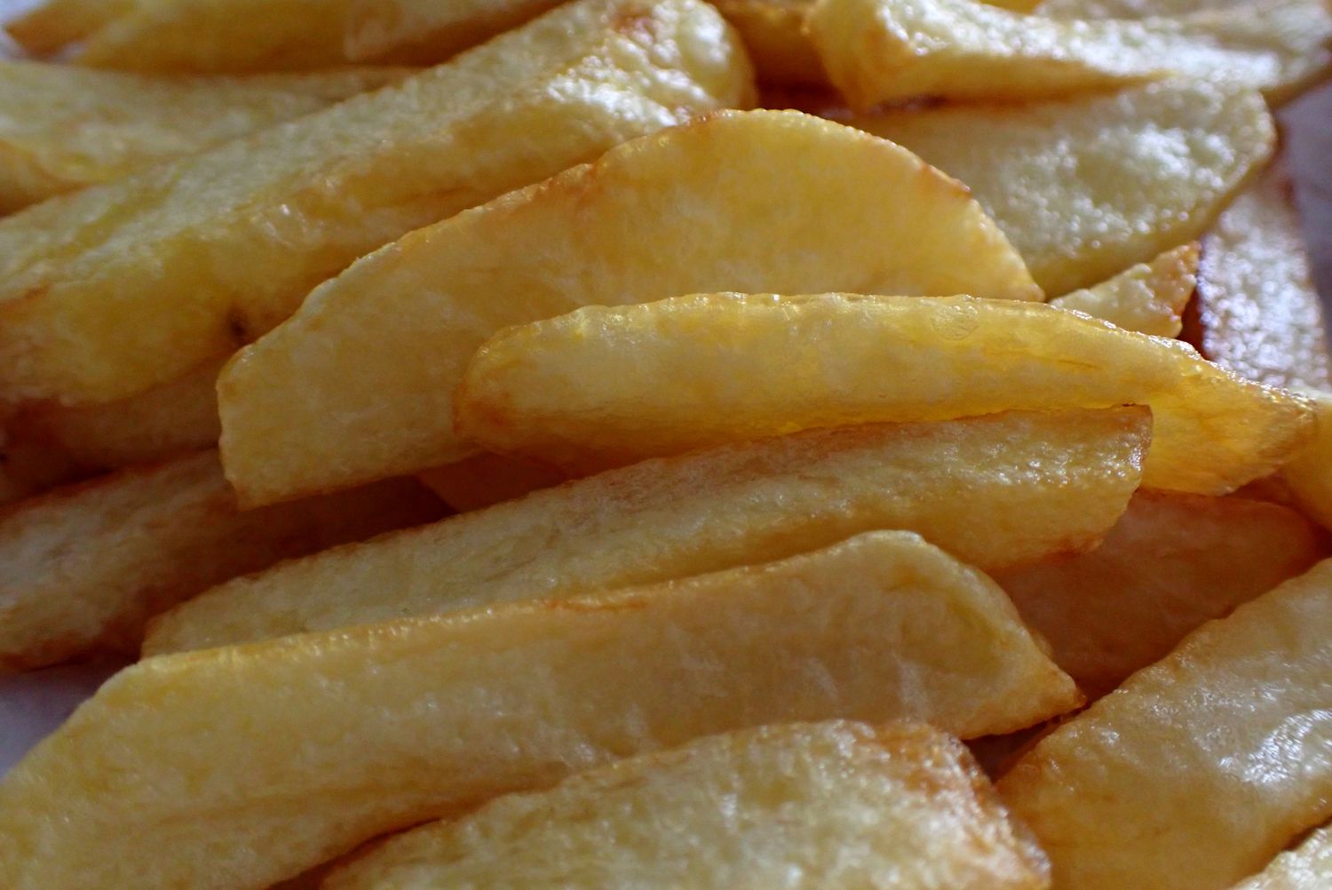 Closeup of golden potato slices fried and arranged on a surface