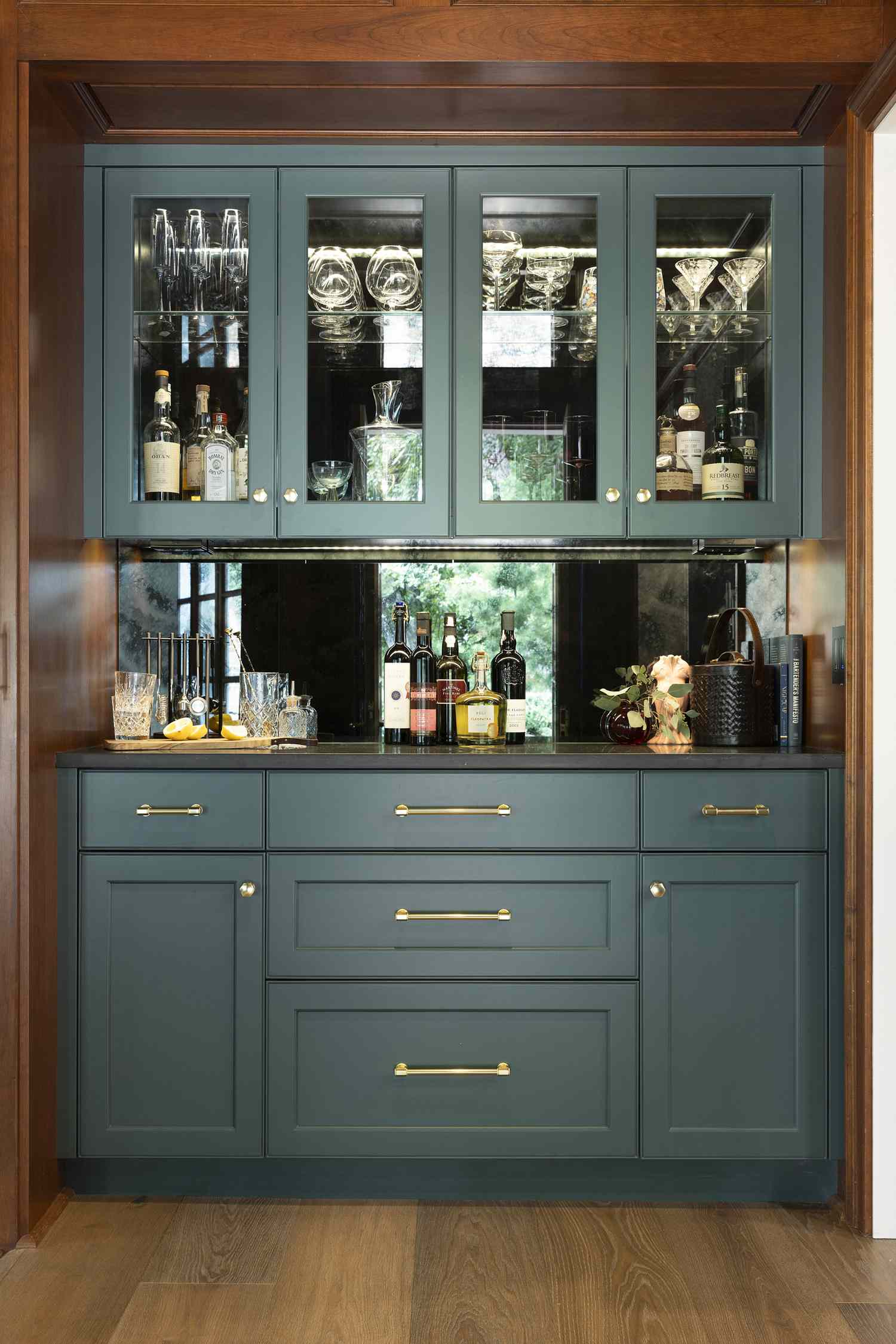 Builtin cabinetry with shelving and mirrored backsplash featuring glassware and spirits