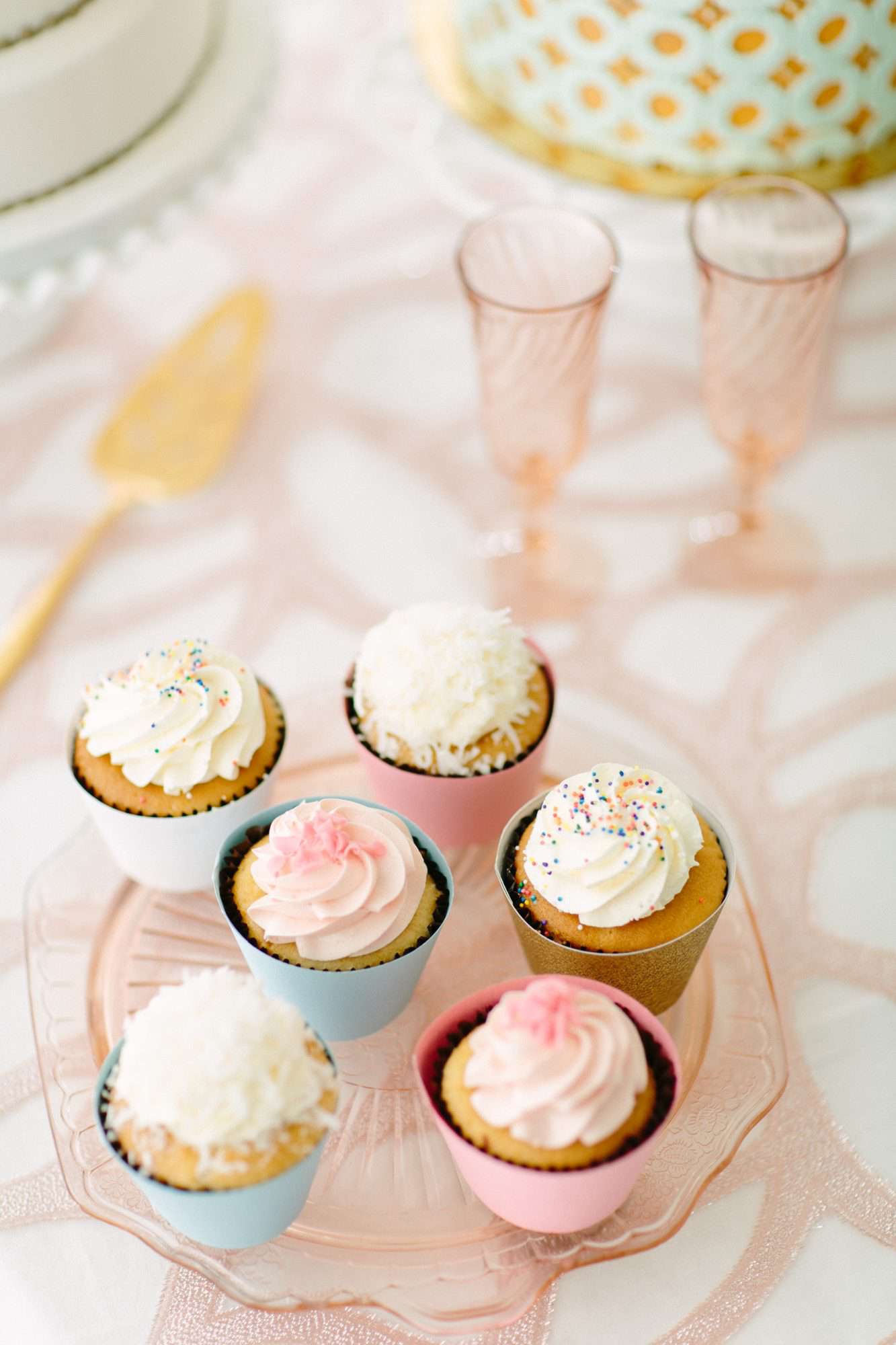 vanilla frosted cupcakes with rainbow and pink sprinkles