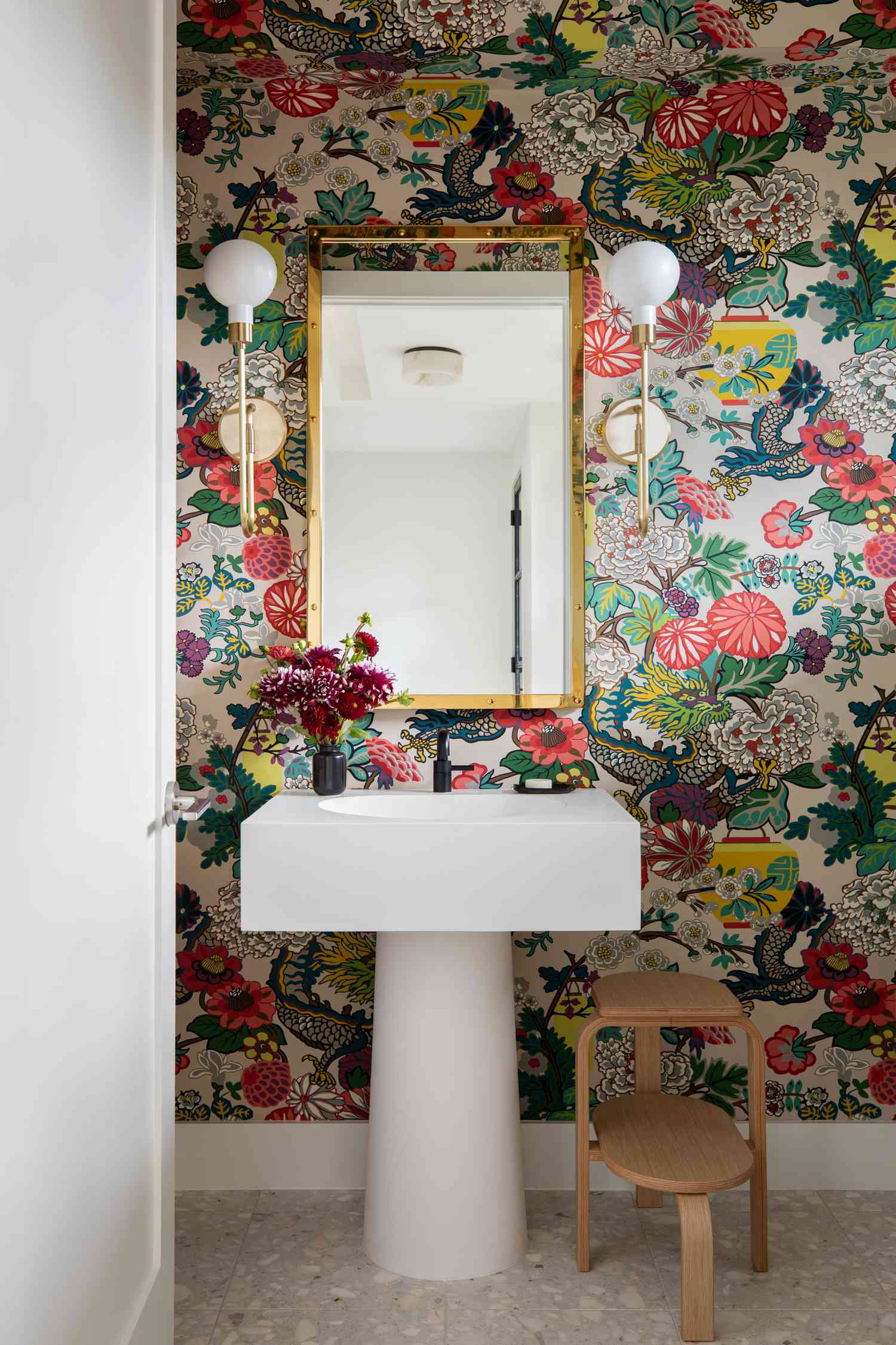 retro modern half bathroom with funky wallpaper and pedestal sink