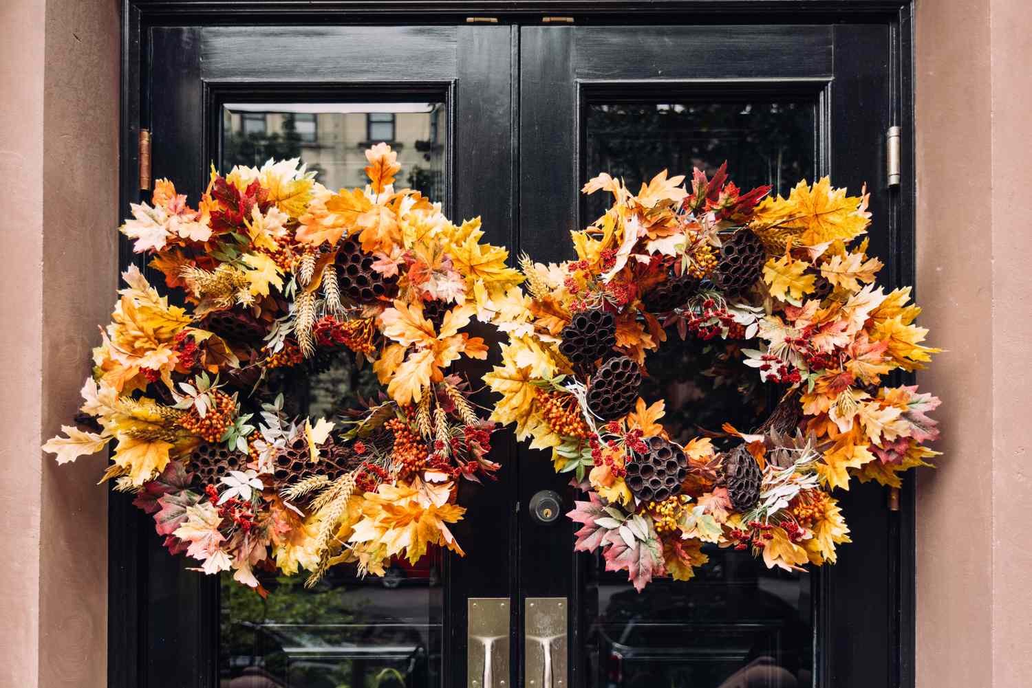 Two autumnthemed wreaths adorning a set of double doors