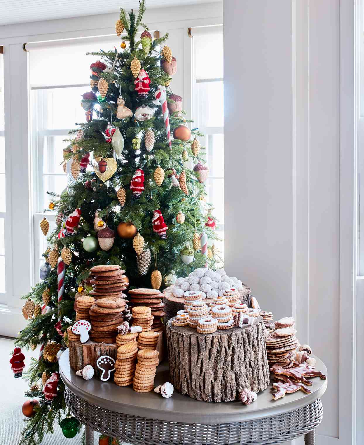 table of holiday cookie varieties in fornt of decorated tree