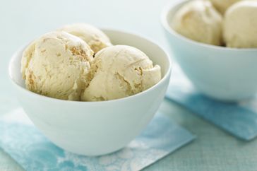 Two bowls filled with scoops of ice cream placed on bluepatterned napkins
