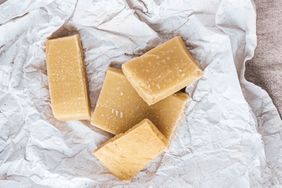 Several rectangular pieces of hard cheese on crumpled parchment paper