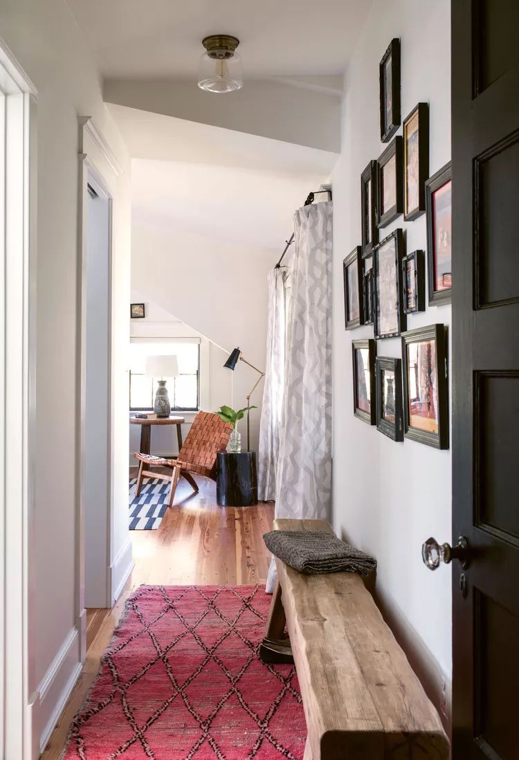 Hallway with wooden bench and gallery wall