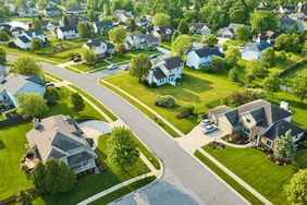 A suburban neighborhood with houses streets and trees seen from an aerial perspective