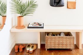 Entryway bench with a potted plant books shoes and a wooden box for storage