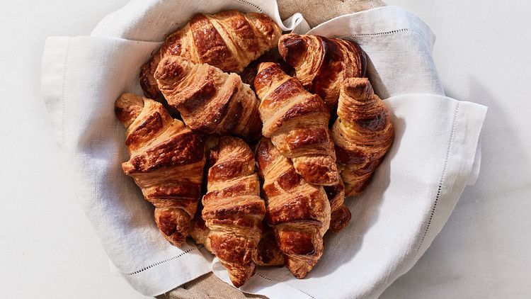 pile of croissants in a linen draped bowl
