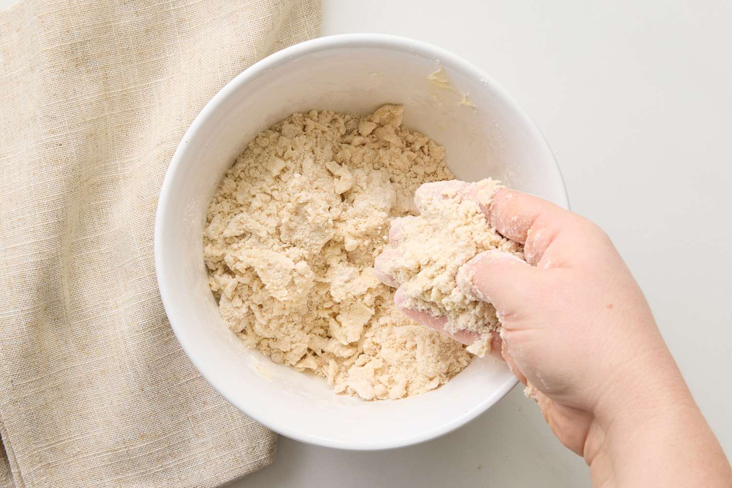 Hand mixing crumb topping in a bowl