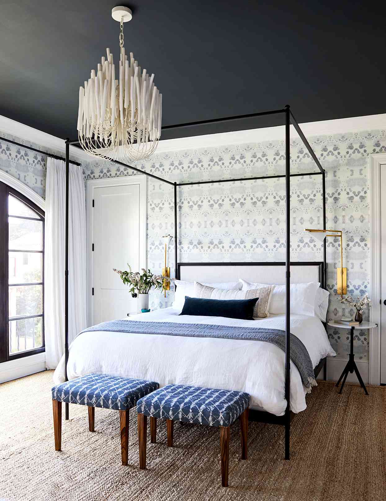 Bedroom with textured wallpaper and blue and white bed